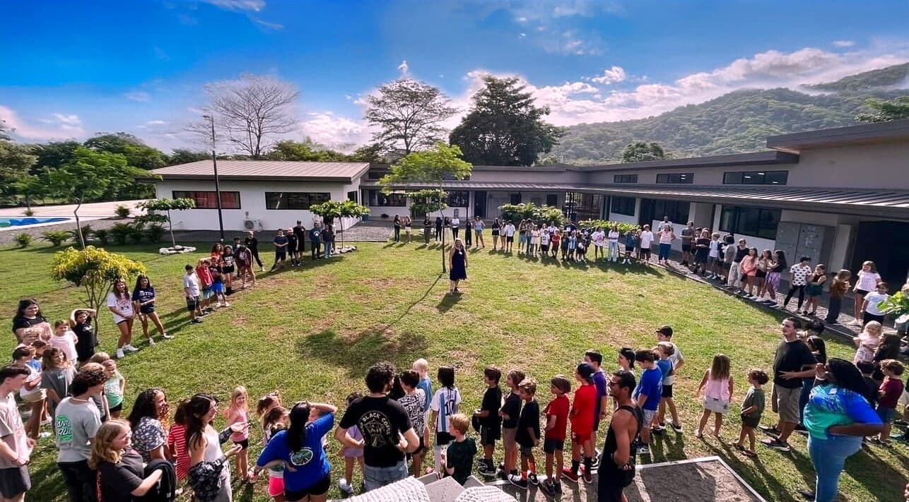 Journey School students gathered in a circle on the campus lawn