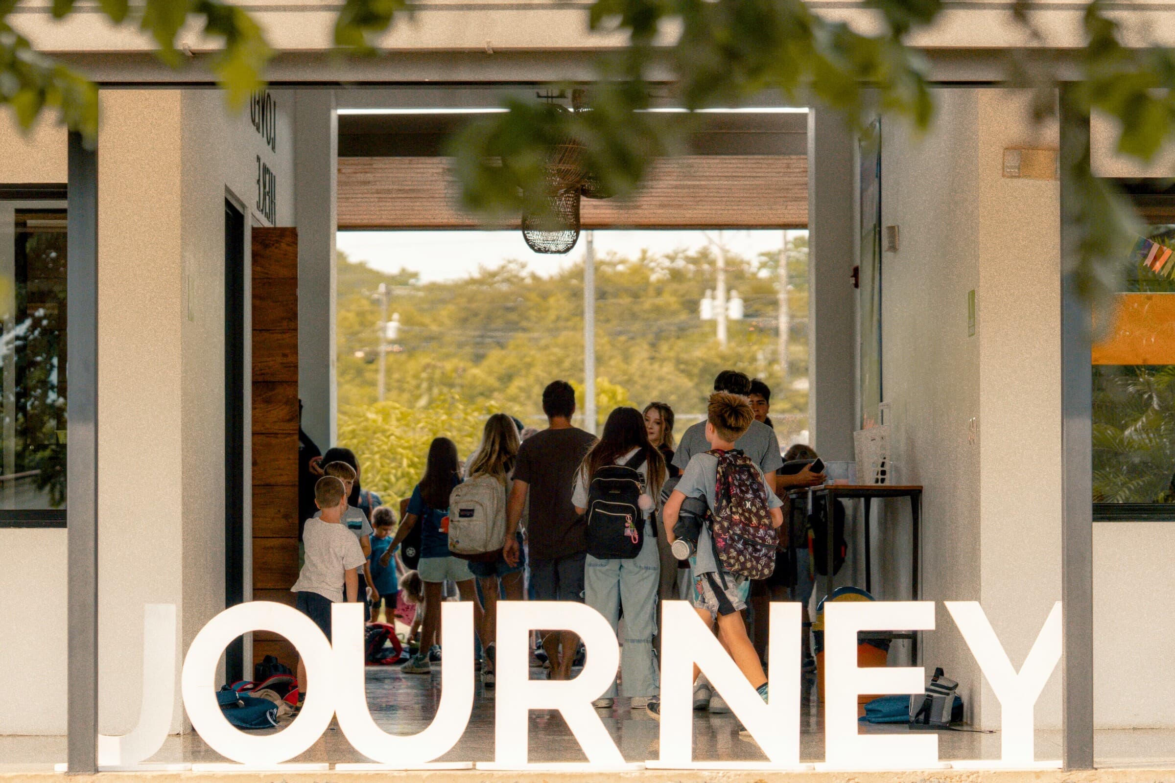 Students walking into Journey School past large JOURNEY letters in the entrance