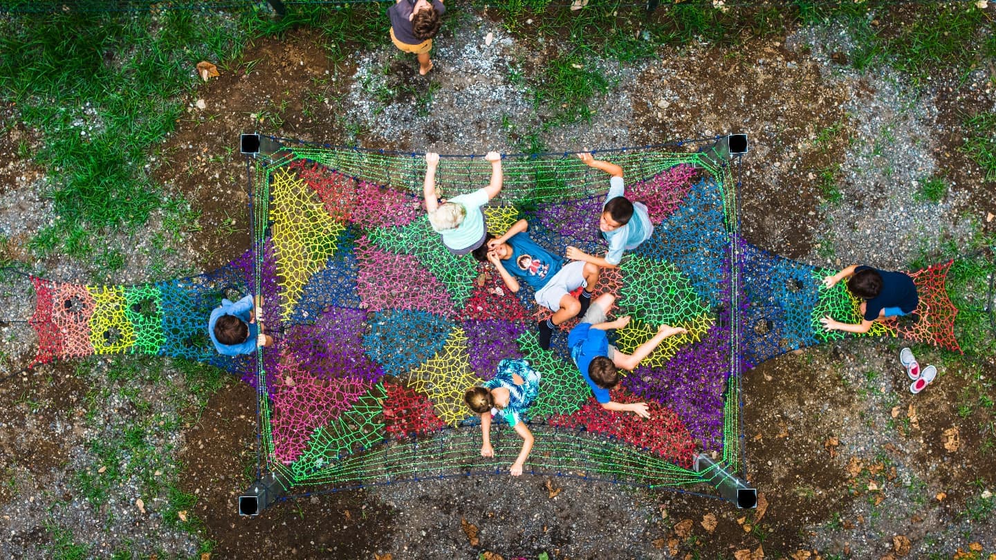 Children playing on a colorful rope climbing net