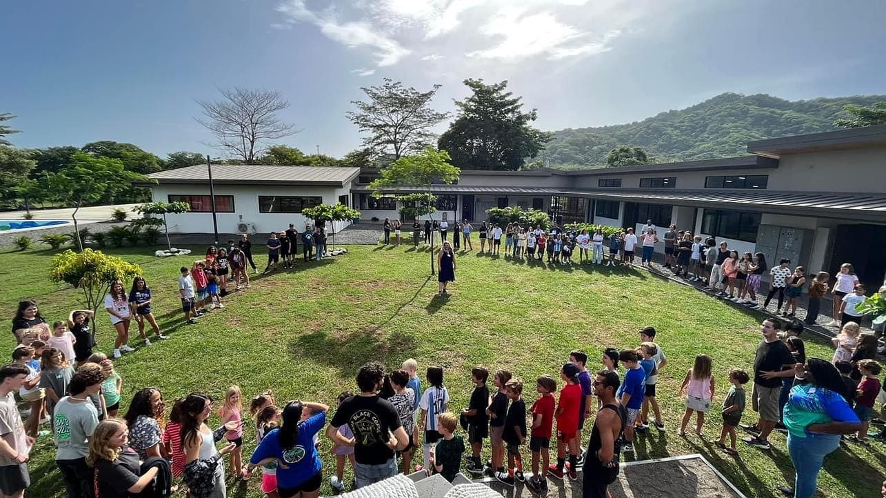 The whole Tamarindo school gathered in a circle on the campus lawn, mountains behind