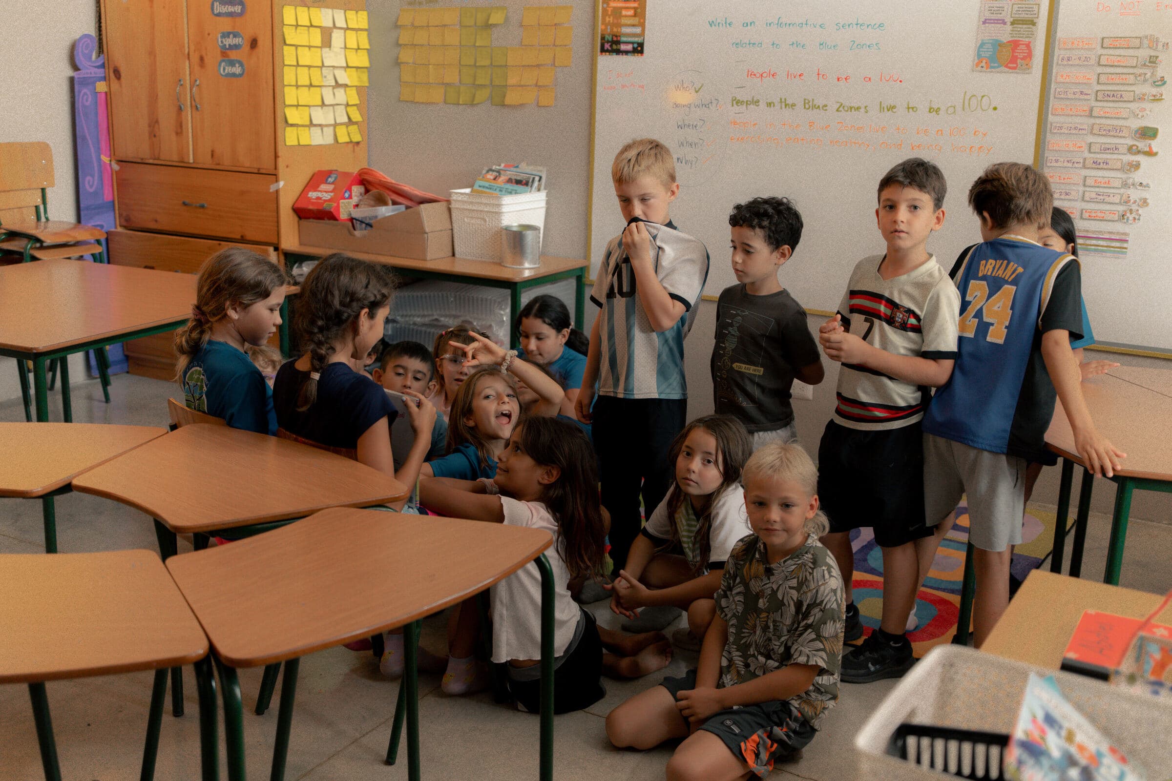 Journey students gathered around a 'Blue Zones' lesson on the classroom whiteboard
